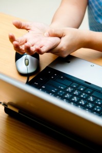 person with wrist pain at laptop